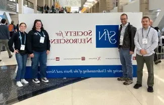 A group of UNE researchers pose in front the Society for Neuroscience sign